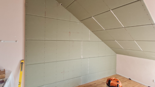 Verlegte Kunststoff-Register für Flächenheizung an Wand und Dachschräge in Innenraum