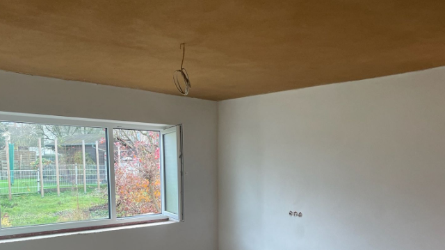 Innenraum mit verputzten Wänden und Decke, Fenster mit Blick ins Freie