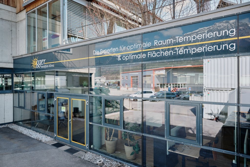 Außenansicht eines modernen Gebäudes mit Beschriftung zu Raum- und Flächentemperierung