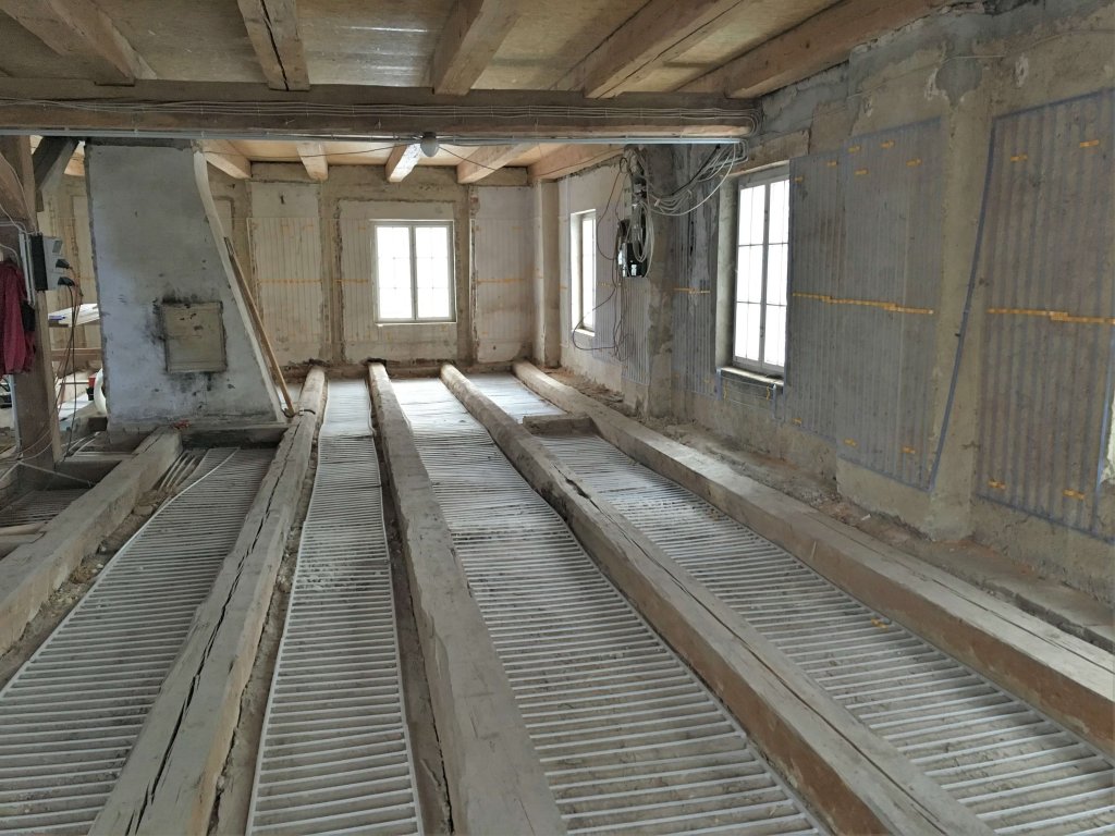 Blick in einen alten Dachboden mit freigelegten Holzbalken und Dämmung
