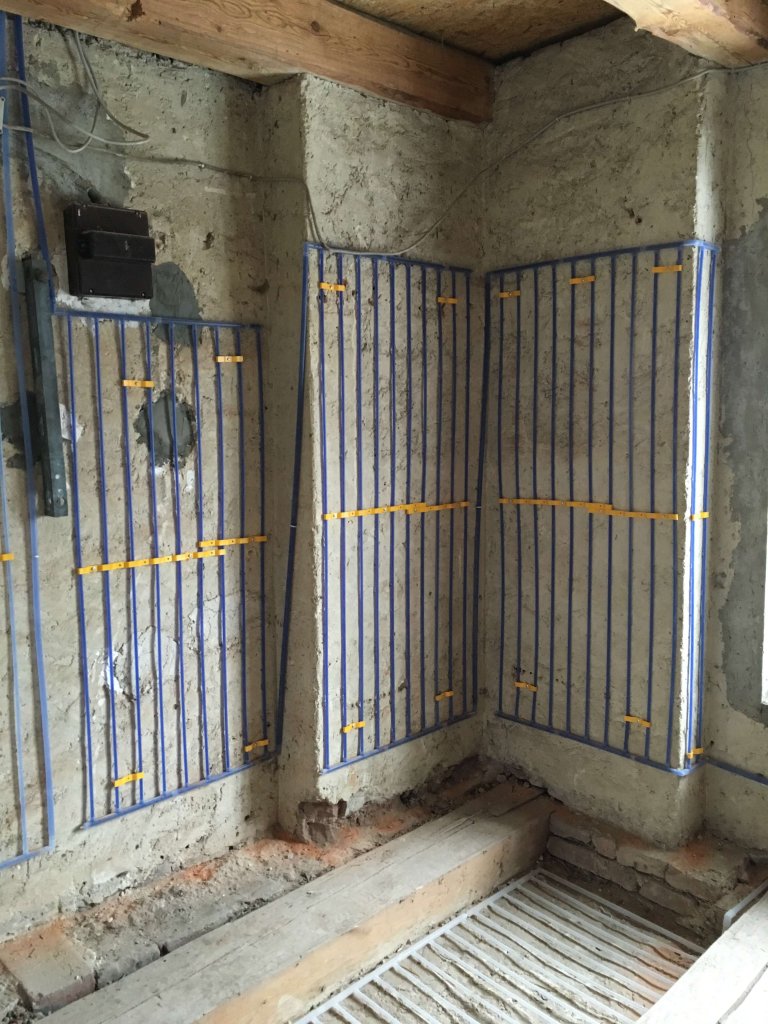 Wand mit installierten Heizrohren in einem Rohbau für Egger Klima