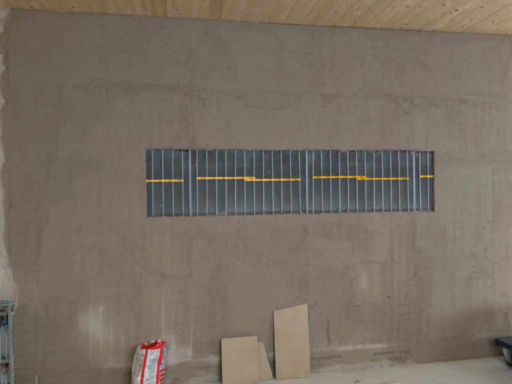 Fenster mit Lamellen in einer unbehandelten Wand in einem Innenraum