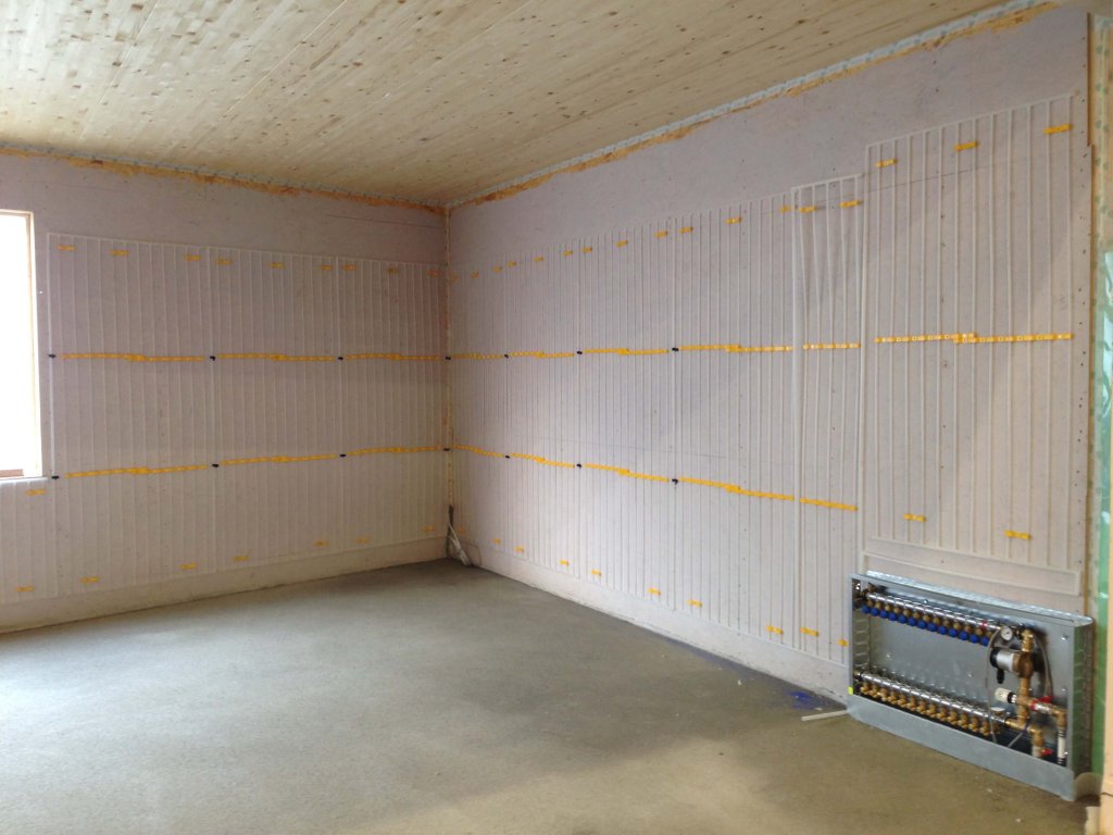 Leerer Raum mit isolierten Wänden und Heizgerät an der Wand