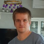 Porträt eines jungen Mannes vor weihnachtlicher Dekoration in einem Wohnzimmer