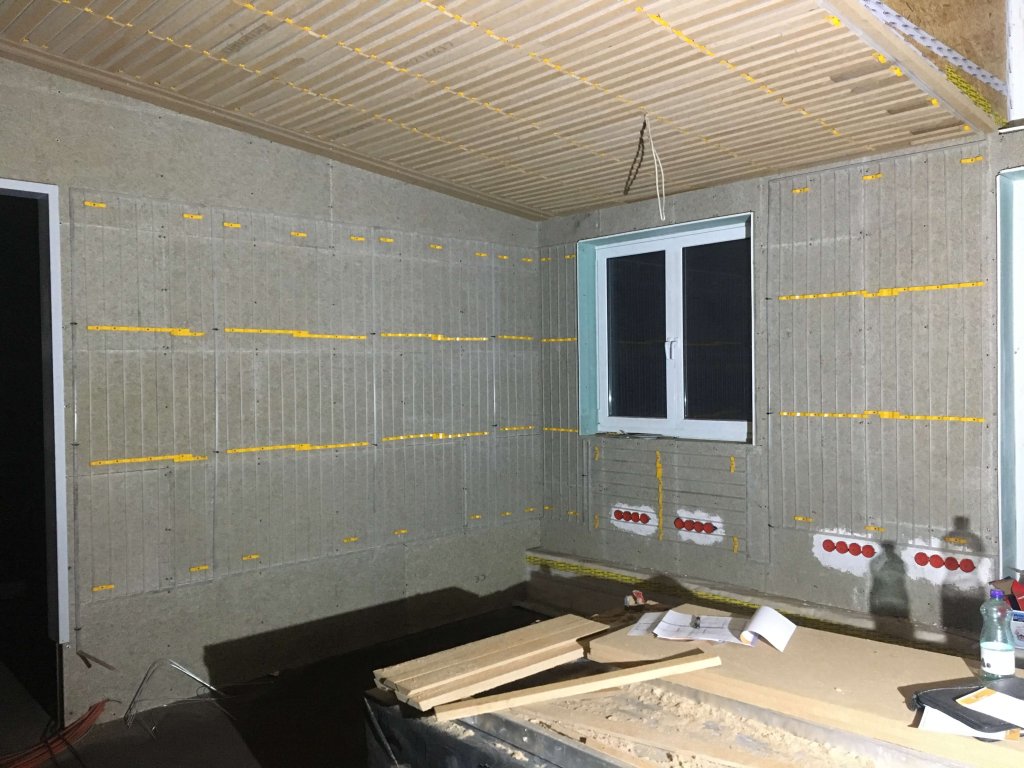 Innenraum mit Dämmplatten an Wänden und Decke während der Bauphase