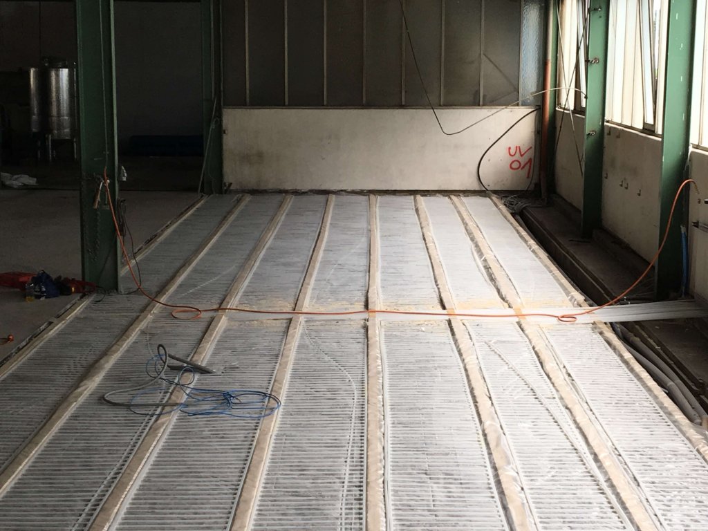 Bodenheizung wird in einem großen Raum installiert mit sichtbaren Heizleitungen