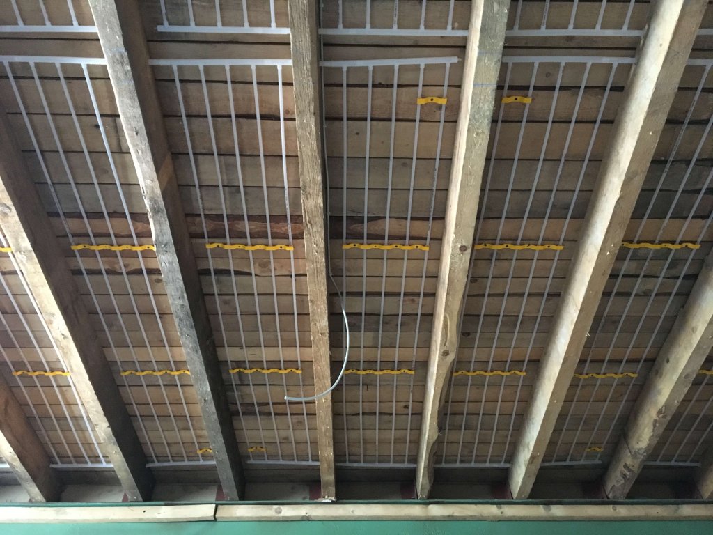 Blick auf eine Decke mit Holzbalken und installierten Gittern für Klimaanlage