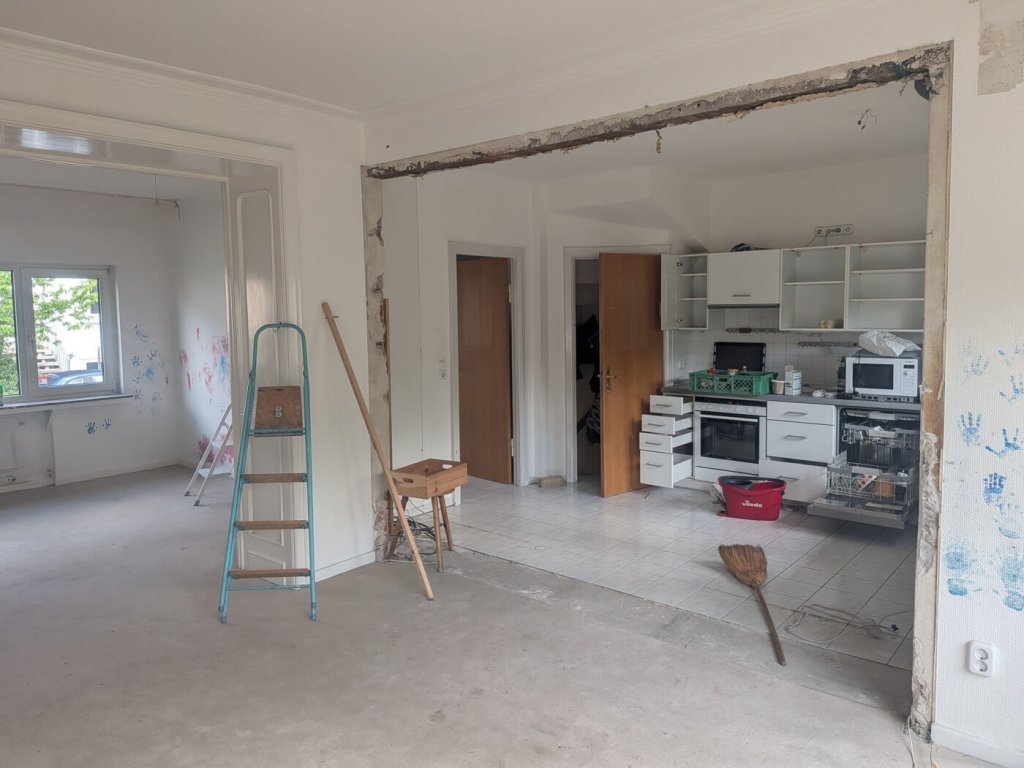 Innenraum einer Wohnung im Umbau mit offener Küche und Baustellenmaterial