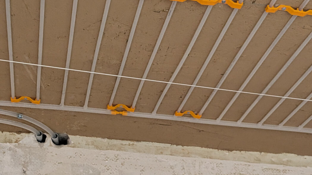 Deckeninstallation mit Rohrleitungen und Befestigungselementen für Klimasystem